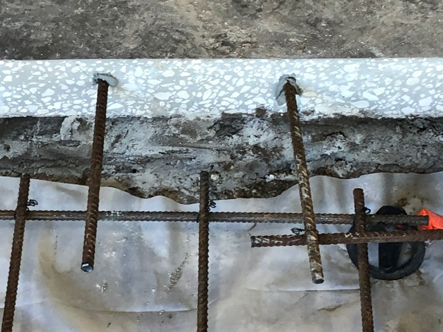 Steel dowels drilled into the edge of the existing slab.