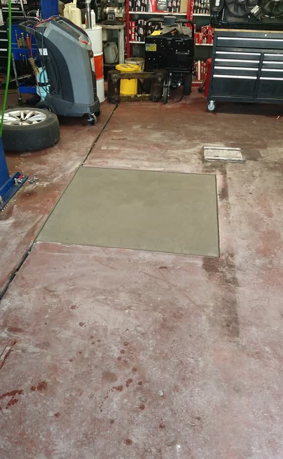 Finished square concrete pad in an automotive shop floor.