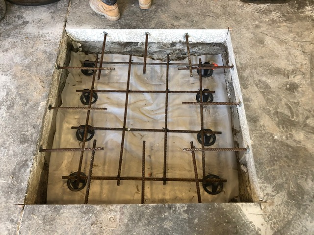 Rebar mat set in a square opening before the pour.
