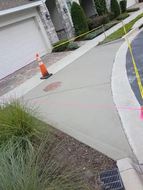 New concrete sidewalk at a house, marked off while it cures.