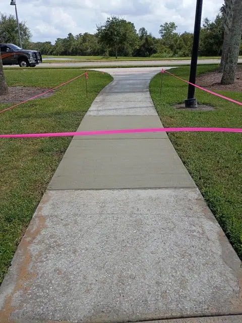 Sidewalk replacement along a residential street, with the work area marked off.