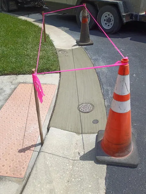 Detectable warning panels on a new sidewalk where it meets the street.